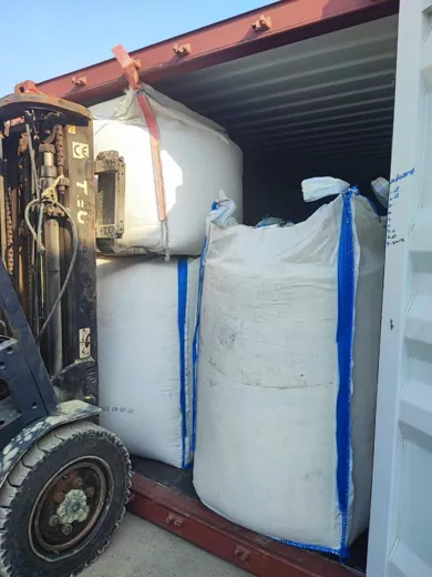 Forklift loading jumbo bags into a container