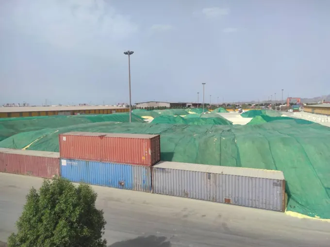 Covered stockpiles and containers in the open yard